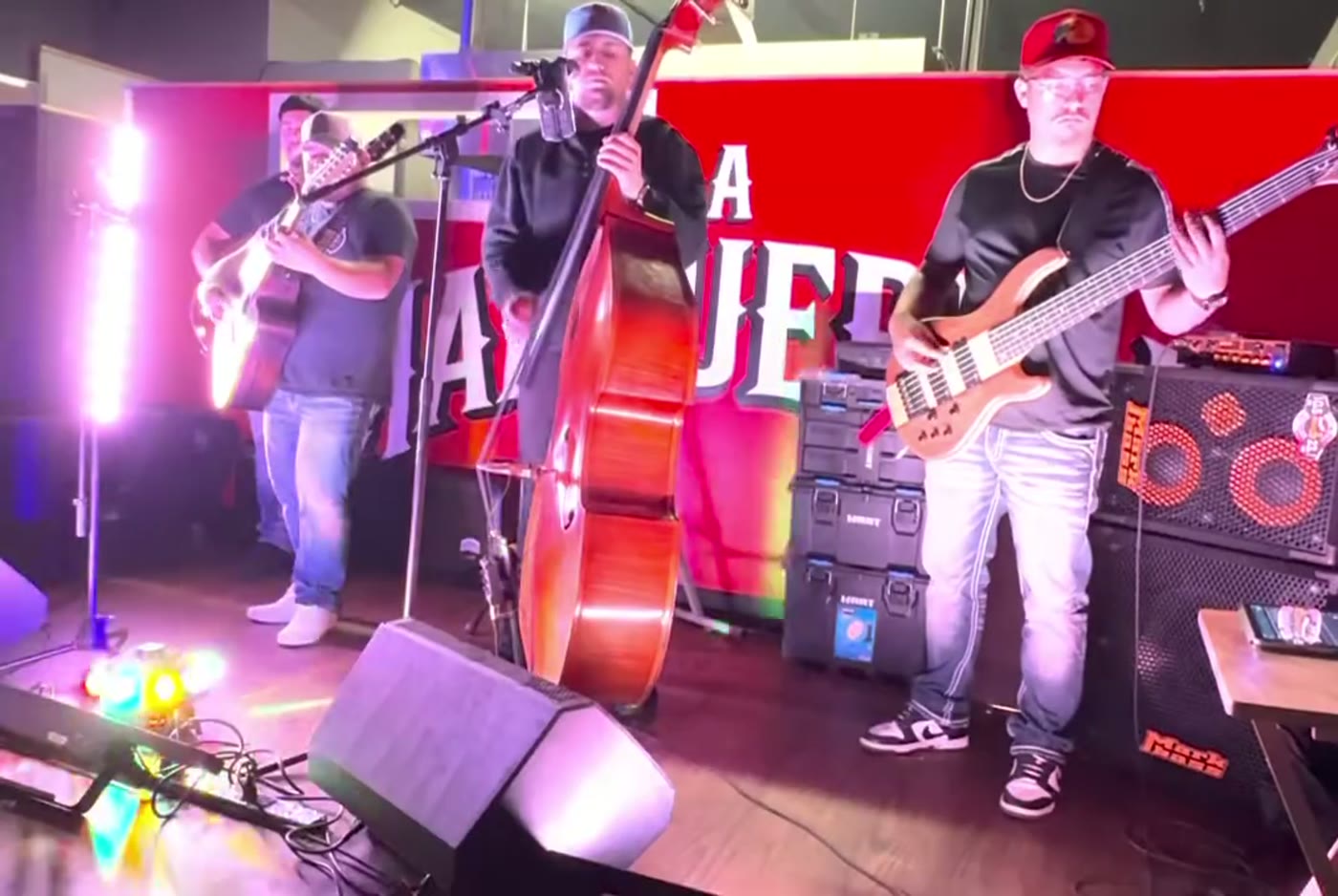 Band lit in red and pink stage lights at La Malquerida