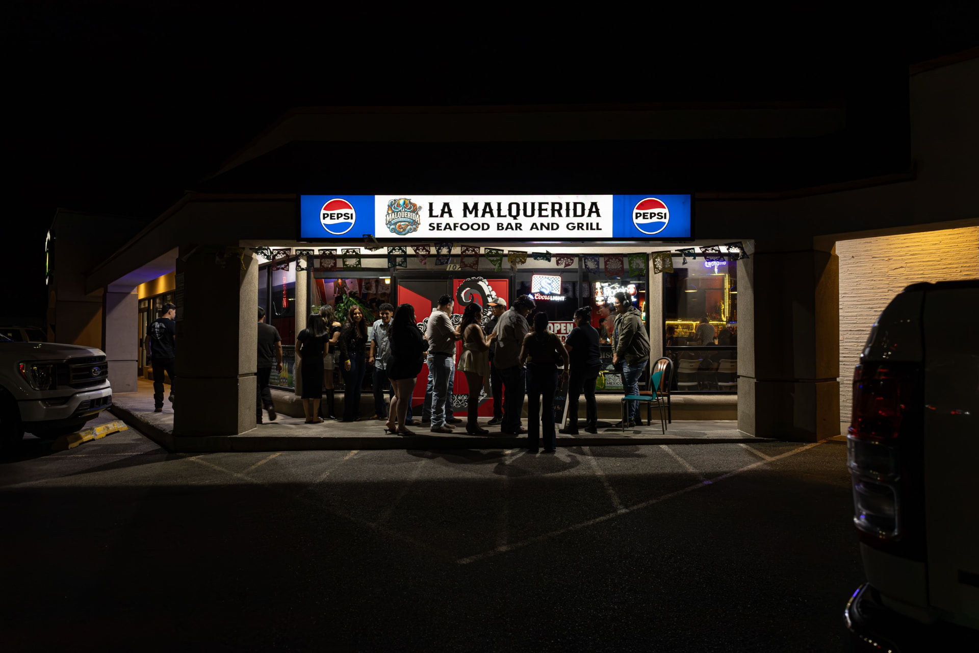 La Malquerida storefront glowing at night