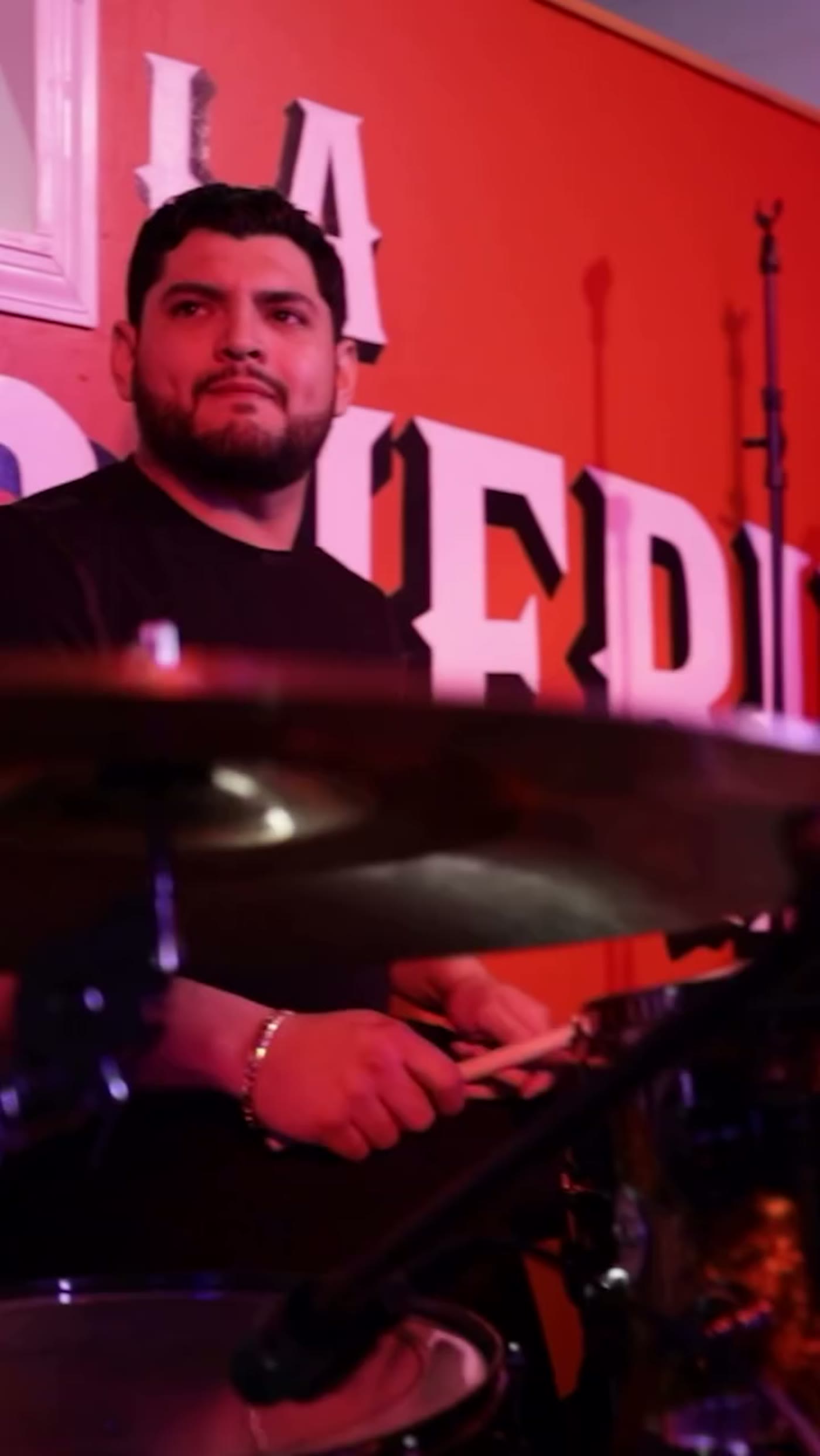 Drummer playing in front of the La Malquerida wall